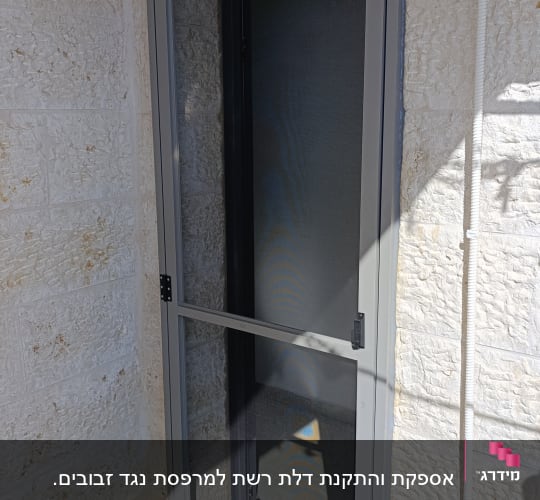דלת אלומיניום אפורה עם רשת על מרפסת
